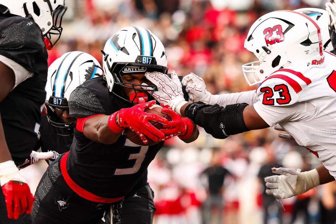 North Crowley running back G'Yrell Smith leaps while holding the ball out toward the goal line while Coppell linebacker Lincoln Gardner (23) puts his hand in his face.