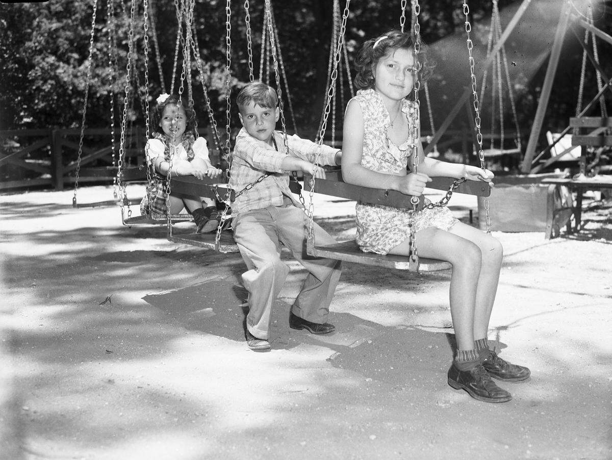 May 22, 1945: Grapevine, Texas, school children visiting Forest Park in Fort Worth. James Sanders, first-grader, and Julie Ann Melton, second-grader, prepare for a ride on the swings.