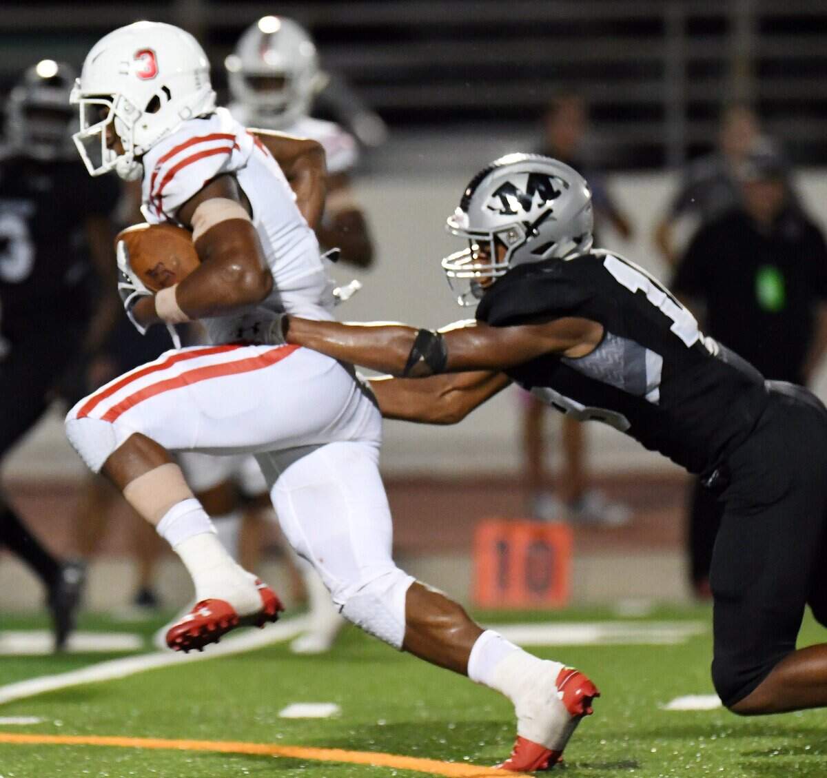 Austin Lake Travis’s Sean Brown-Nixon, left, tries to pull away from Martin’s Morice Blackwell as he gets a first down near the goal line in the third quarter of Friday’s August 31, 2018 football game at Maverick Stadium in Arlington.