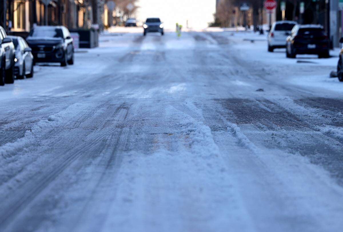 Melted slush and snow cover South Main Street near downtown Fort Worth as the sun sets on Monday, Jan. 26, 2026. As melted ice refreezes overnight there is a chance black ice will be an issue in North Texas.