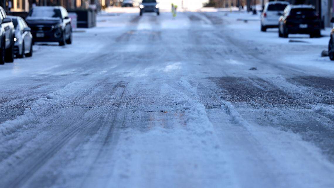 Melted slush and snow cover South Main Street near downtown Fort Worth as the sun sets on Monday, Jan. 26, 2026. As melted ice refreezes overnight there is a chance black ice will be an issue in North Texas.