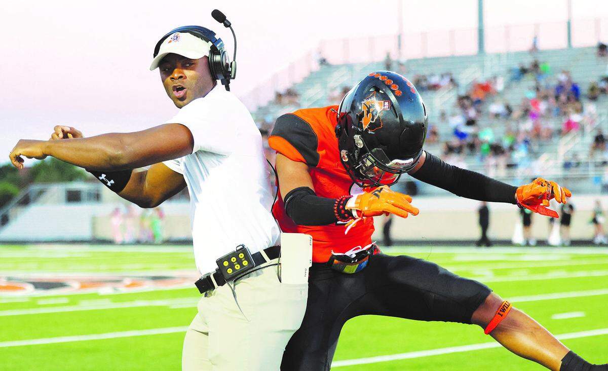 Aledo assistant football coach Johnathan Gray and Patrick-Daniels celebrate after a play. Gray was a Texas high school legend when he played for the Bearcats