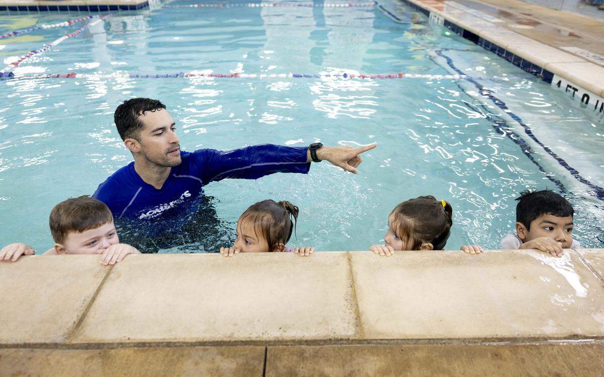 Swim Instructor Ryan Cleaver teaches toddlers how to navigate water during a lesson at Aqua-Tots Swim School on Thursday, May 21, 2026 in Fort Worth, Texas. The class consisted of learning skills such as breathing, kicking and flipping over to your back while in the water.