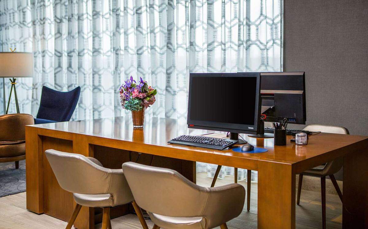 The Cambria hotel in Southlake features a business center with desks, chairs and computer monitors.