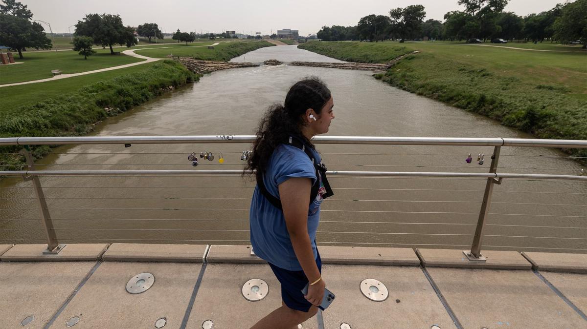 Carina Contreras goes for a walk across a bridge at Trinity Park in Fort Worth on Tuesday, June 4, 2024.