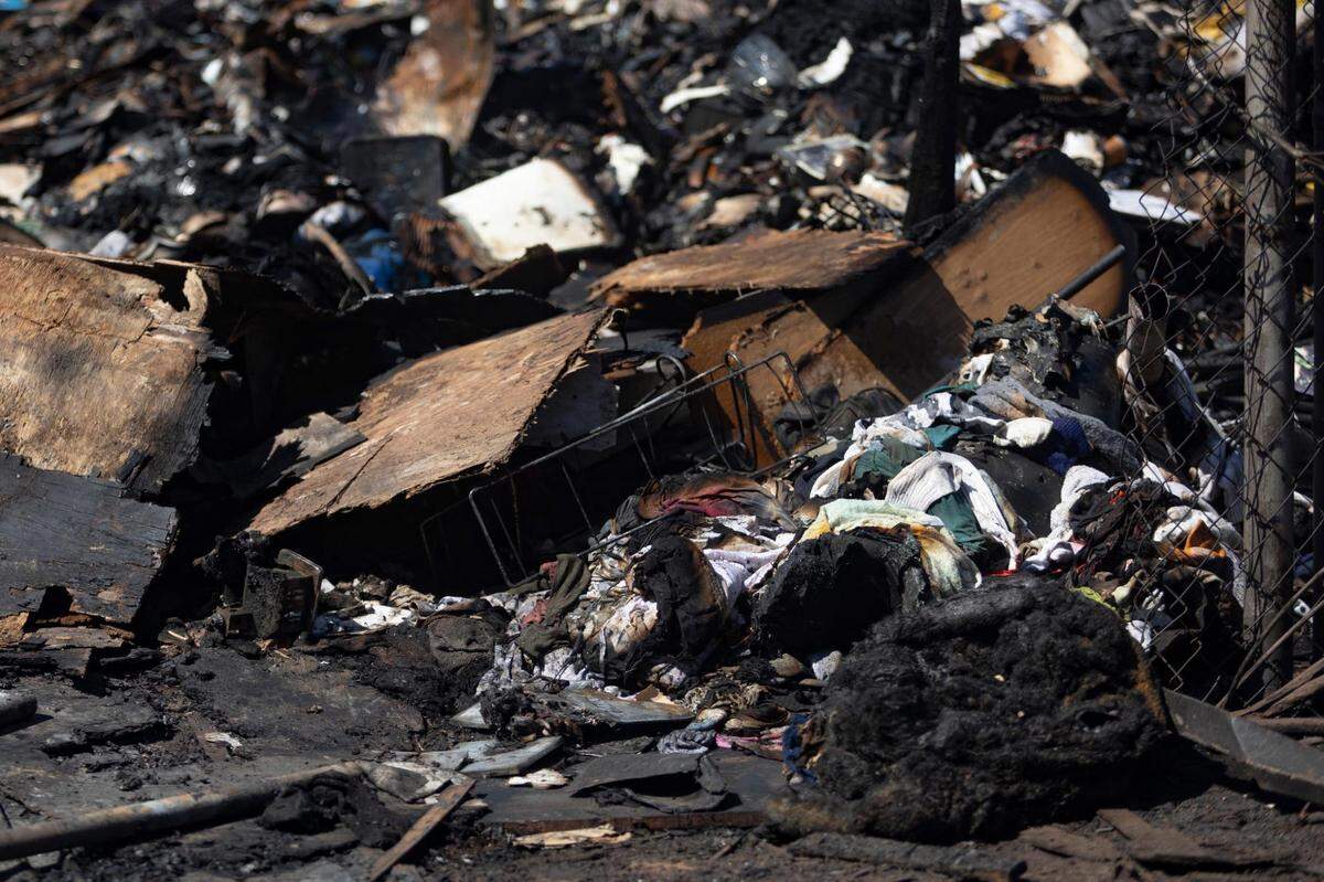 Charred clothing and objects lay in a pile after a home fire in Rendon, Texas, on Wednesday, July 27, 2022.