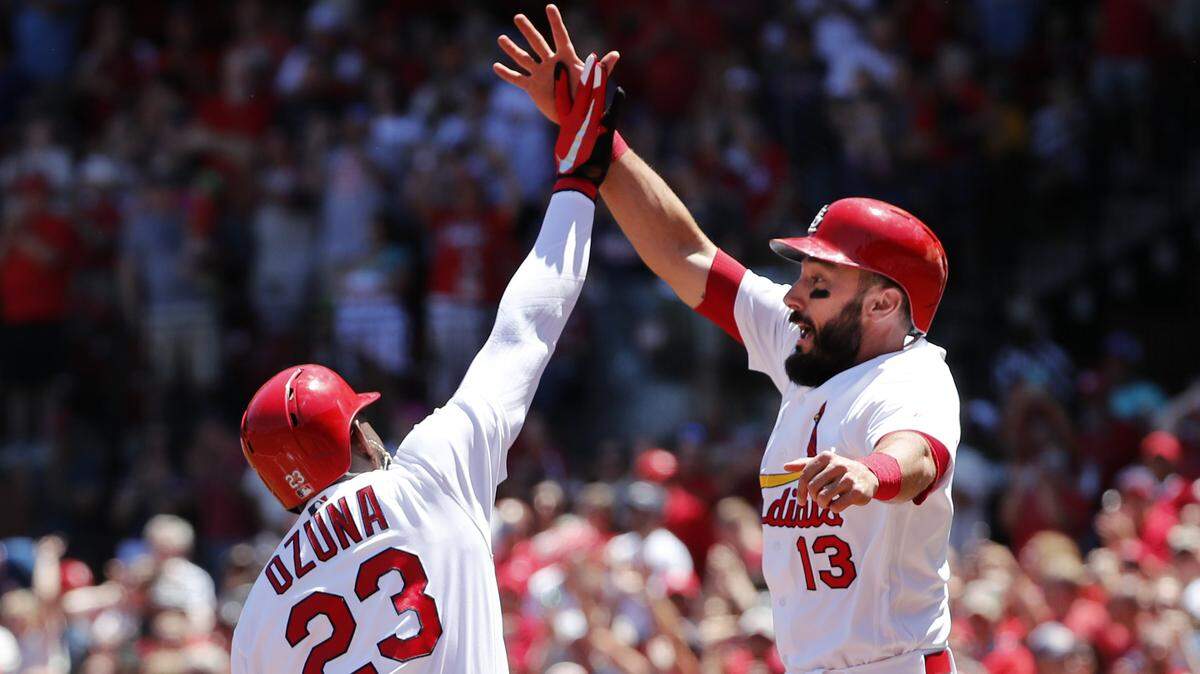 The Cardinals' Marcell Ozuna, left, is congratulated by teammate Matt Carpenter after hitting a grand slam on June 3 in St. Louis.