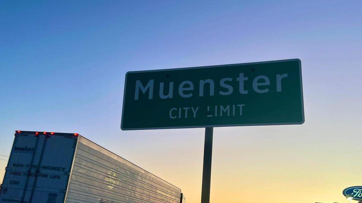 The Muenster city limits sign at sunset