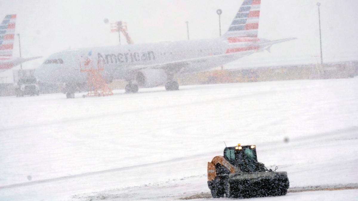 FILE -- Snow and ice are cleared from the tarmac at Dallas Fort Worth International Airport in Grapevine, Texas, Thursday, Feb. 3, 2022. A major winter storm with millions of Americans in its path is spreading rain, freezing rain and heavy snow further across the country. (AP Photo/LM Otero)