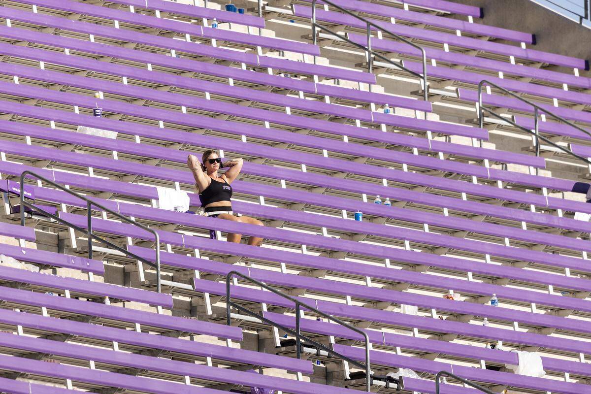 A fan sits alone in the stands after three rain delays before resuming action in the second half of a Big XII football game between the TCU Horned Frogs and the Baylor Bears at Amon G Carter Stadium in Fort Worth on Saturday, Oct. 18, 2025.