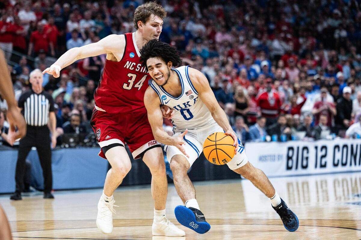NC State forward Ben Middlebrooks (34) guards Duke guard Jared McCain (0) in the second half of the Elite 8 South Regional Championship game between the Duke Blue Devils and NC State Wolfpack of NCAA Division I Mens Basketball Tournament at American Airlines Center in Dallas on Sunday, March 31, 2024. NC State defeated Duke 76-64.