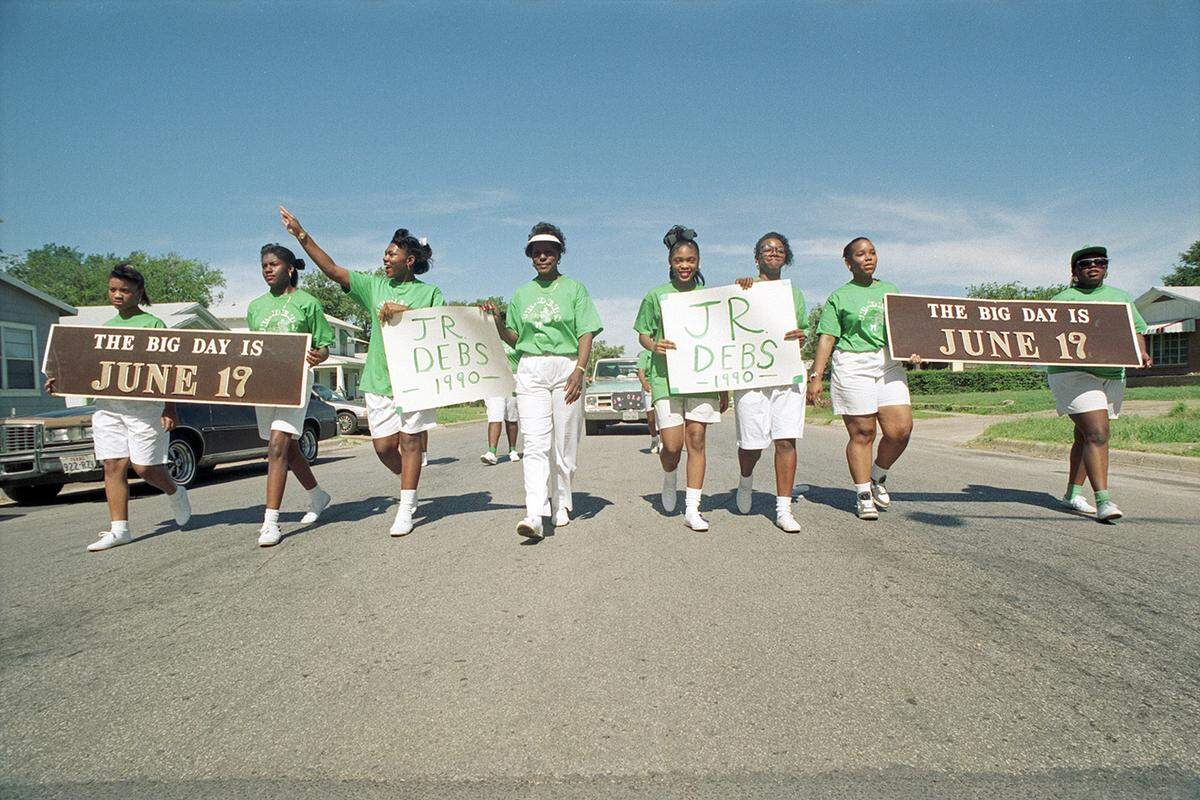 June 16, 1990: Members of the Junior Debutantes of Fort Worth participating in the Juneteenth parade. They are seen carrying signs reading "The Big Day is June 19" and "Jr. Debs 1990."