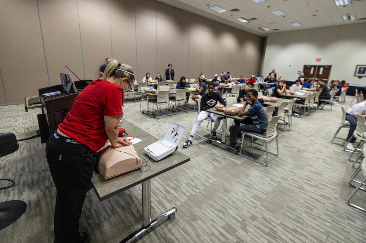 Joy Khan, the HEB ISD Coordinator of Nursing, shows class attendees how to do chest compressions during a CPR class at the Pat May Center in Bedford on Tuesday, Oct. 29, 2024.
