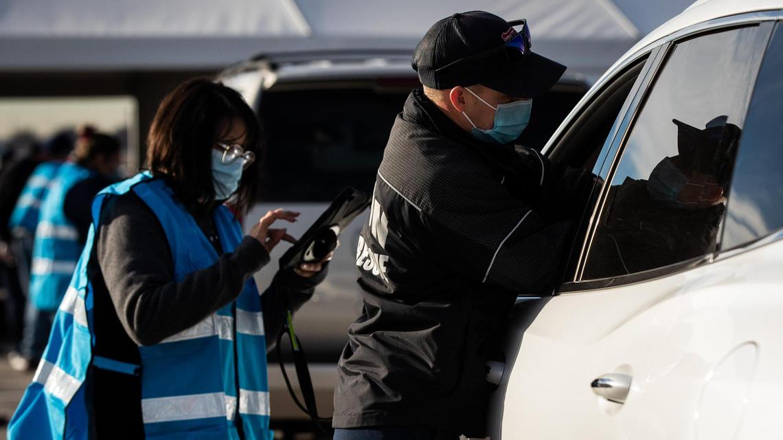 Matt Dieter with Denton Fire Department gives a COVID-19 vaccination in February at Texas Motor Speedway.