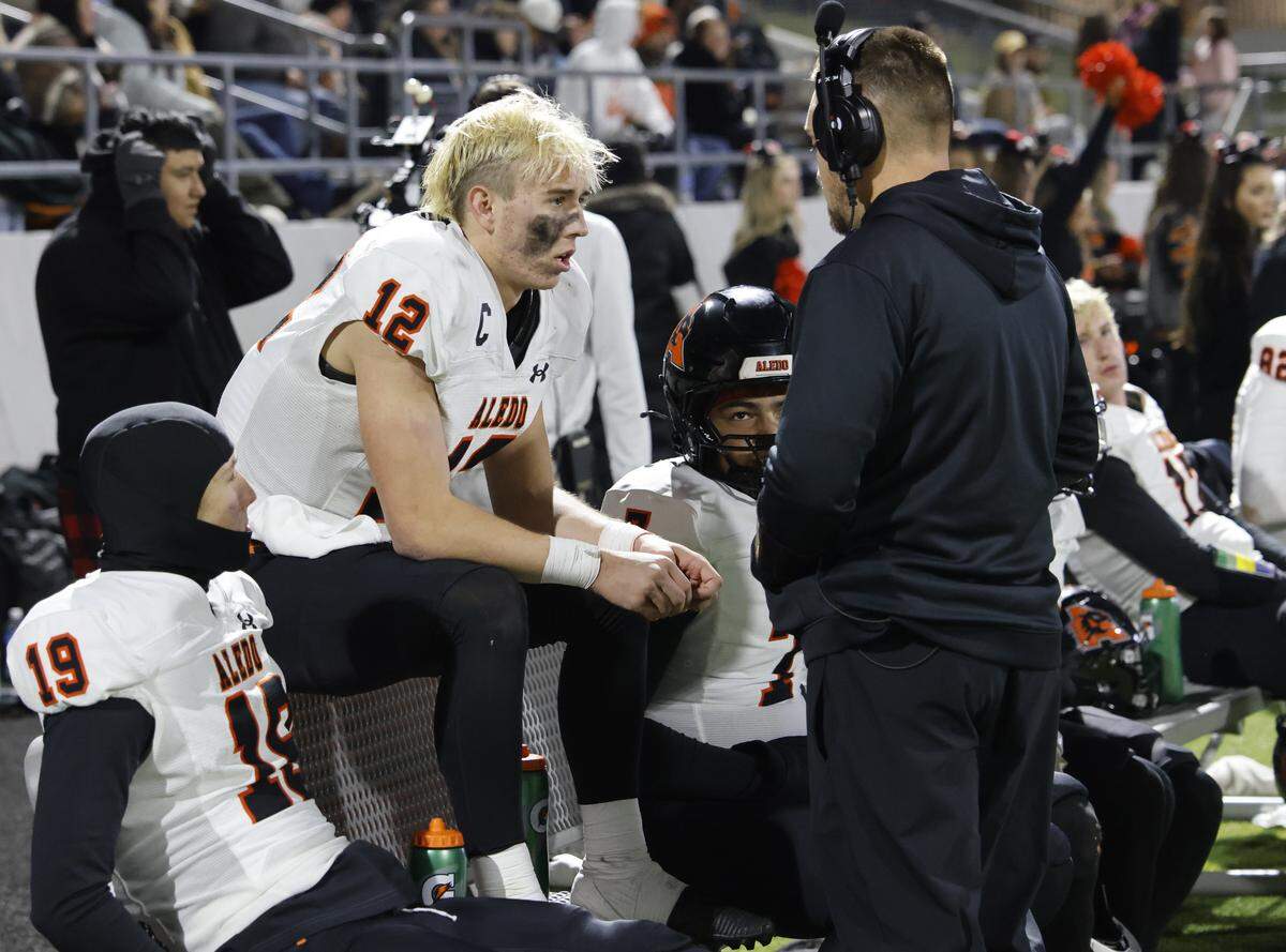 Aledo quarterback Lincoln Tubbs (12) talks with receivers coach Dawson Lake during the second half of a UIL Class 5A Division I Quarterfinal on Friday Dec. 05, 2025 at Northwest ISD Stadium in Fort Worth, Texas.