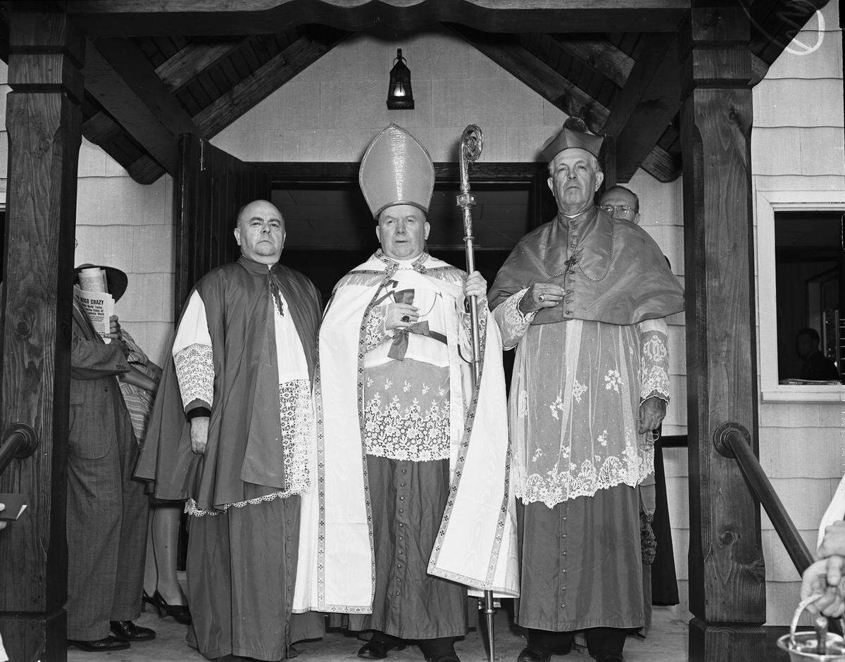 The three men are wearing ceremonial robes. Bishop O'Brien is holding a staff. 
