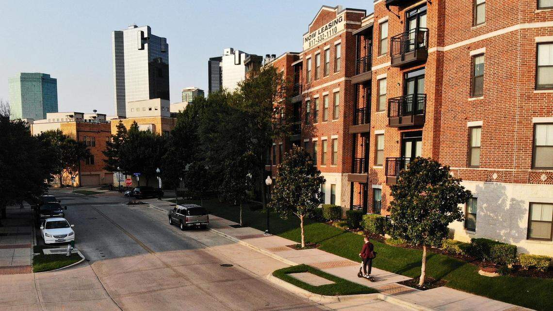 A man rides a scooter down the sidewalk in front of one of the many apartment complexes along the Trinity River near Samuels Avenue. Rental prices continue to rise causing many to struggle to pay rent each month.