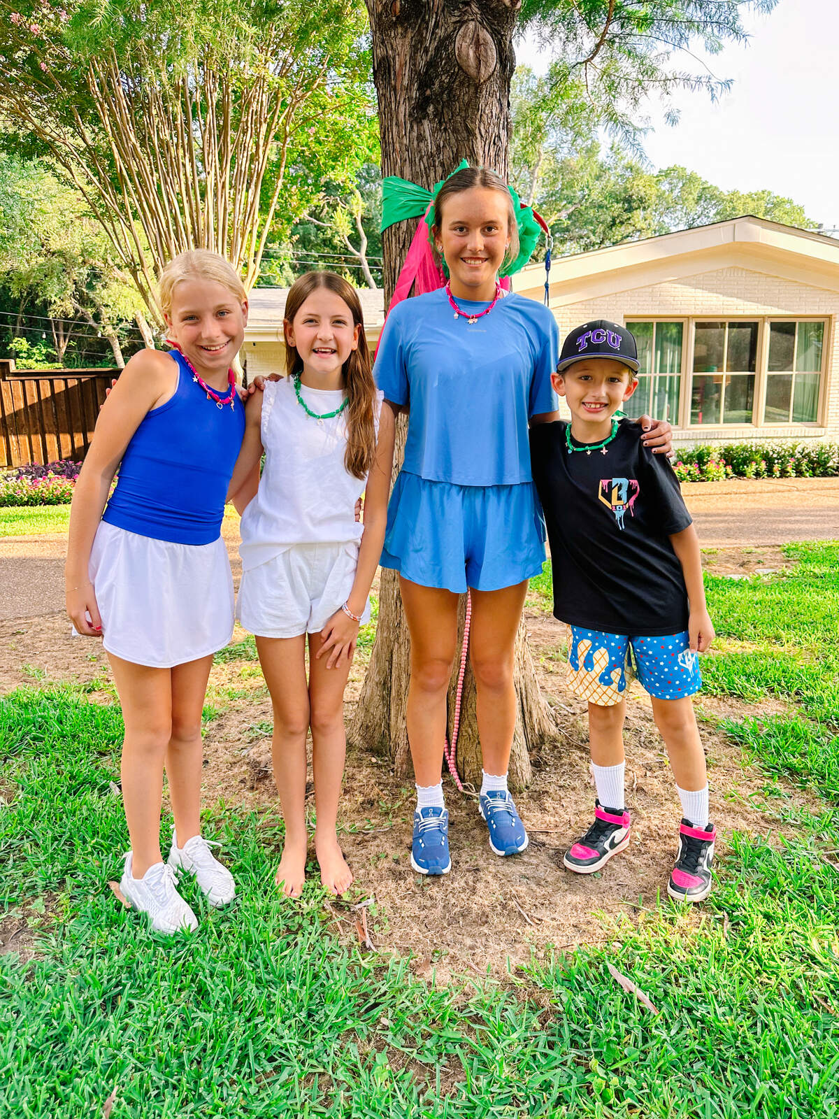 From left to right, Piper Twist, Allie Grace Anderson, Cate Heiszek, and Bo Pollock pose together on July 8, 2025, with bandanna necklaces they helped make and sell to raise funds for Camp Mystic and Central Texas flood relief.