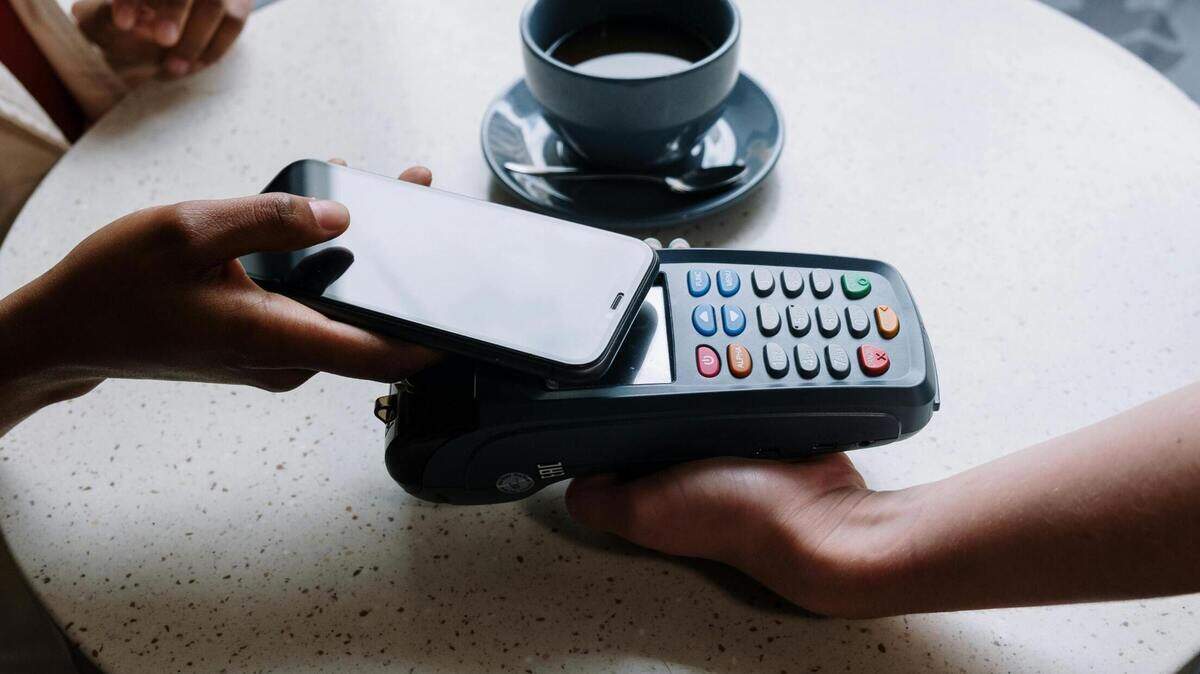 A customer using an iPhone as a form of contactless payment.