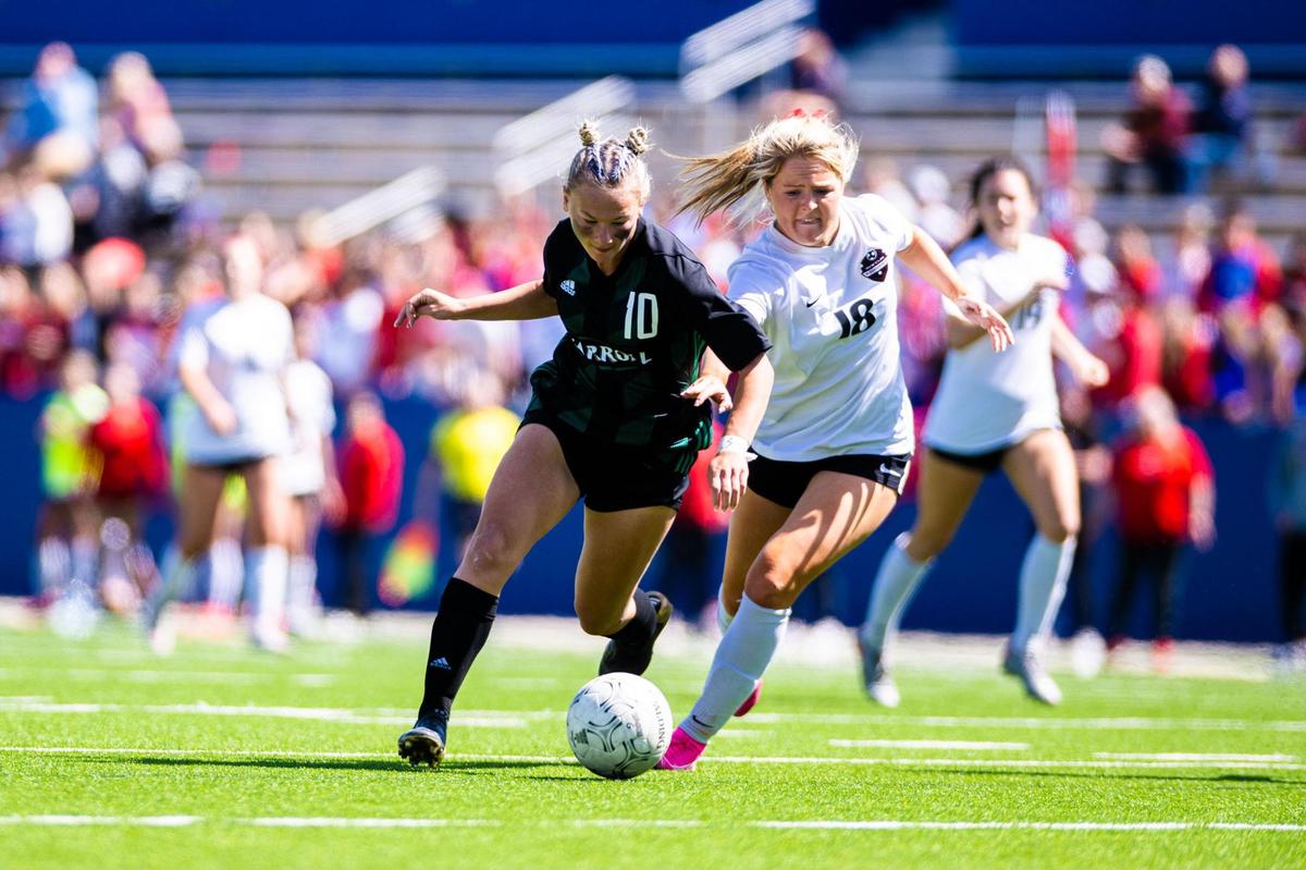 Kennedy Fuller (10) runs battles to maintain possession of the ball during the 6A Regional Final between the Carroll Lady Dragons and the Marcus Marauders at McKinney ISD Stadium on April 9th, 2022.