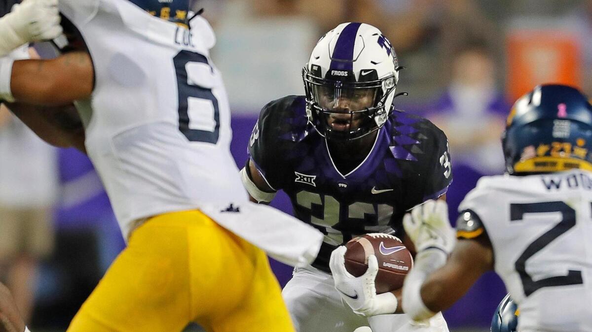TCU running back Kendre Miller (33) looks for running room against West VIrginia at Amon G. Carter Stadium on Oct. 23, 2021. West Virginia defeated TCU 29-17.