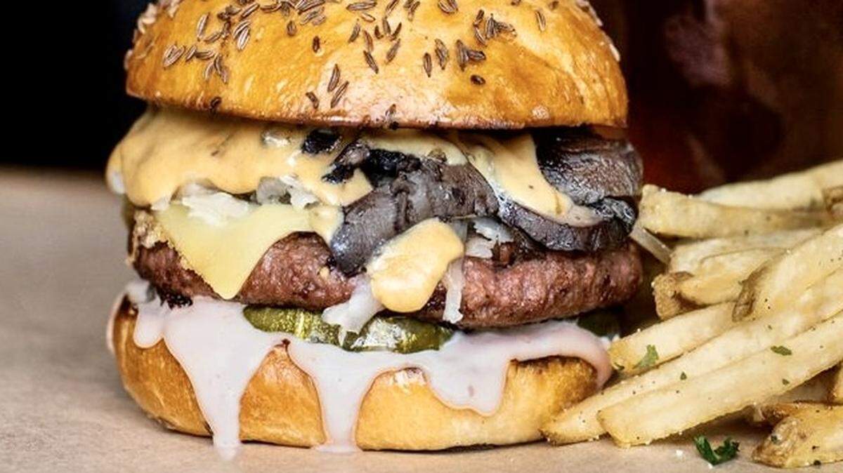 A promotional photo of the Hopdoddy Beyond Meat burger with mushrooms, Gruyere and Russian dressing.