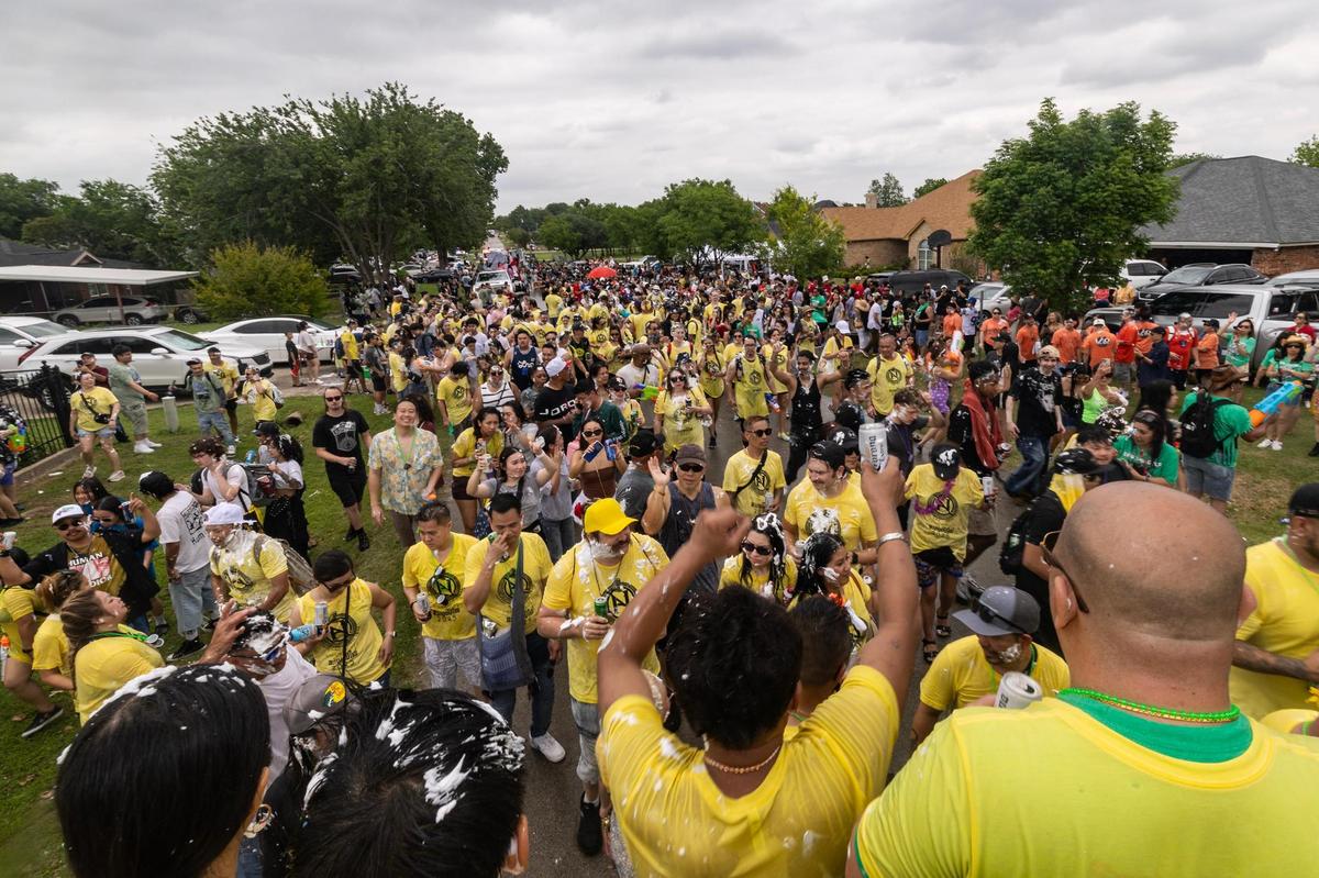 Festival attendees follow the ‘AsianNights’ parade float during the Lao New Year parade on the third day of the Lao New Year festival at Wat Lao Thepnimith Temple in Saginaw on Sunday, April 27, 2025.