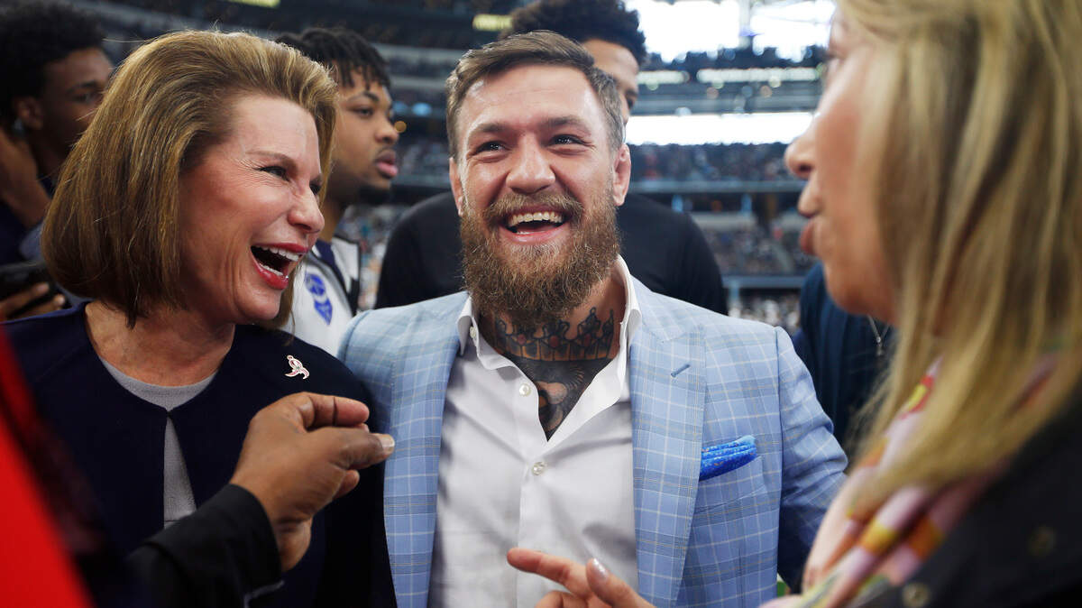 Susan G. Komen for the Cure Founder Nancy Brinker, left, and UFC fighter Conor McGregor are seen on the sidelines before an NFL football game against the Jacksonville Jaguars in Arlington, Texas, Sunday, Oct. 14, 2018.