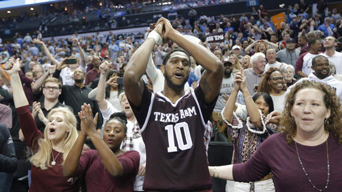 Texas A&M's Tonny Trocha-Morelos (10) celebrates with fans after a win over North Carolina in a second-round game in the NCAA men's college basketball tournament in Charlotte, N.C., Sunday, March 18, 2018. (AP Photo/Bob Leverone)