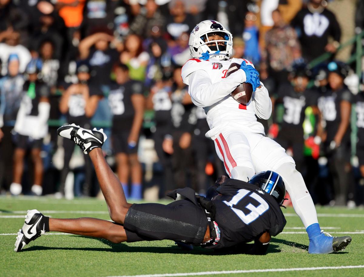 North Crowley’s Quentin Gibson (13) drops Duncanville’s Dakorien Moore (1) on a punt during the first half of a UIL Conference 6A Division I state semifinal football playoff game at Mesquite Memorial Stadium in Mesquite, Texas, Saturday, Dec. 09, 2023. Duncanville led North Crowley 24-0 at the half.