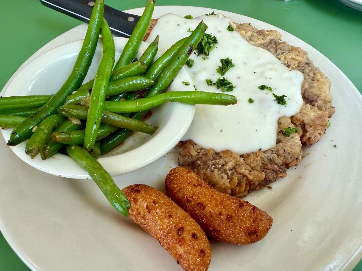 Chicken-fried steak with green beans and hush puppies at Stagecoach Inn Restaurant in Salado, Texas, June 1, 2025.