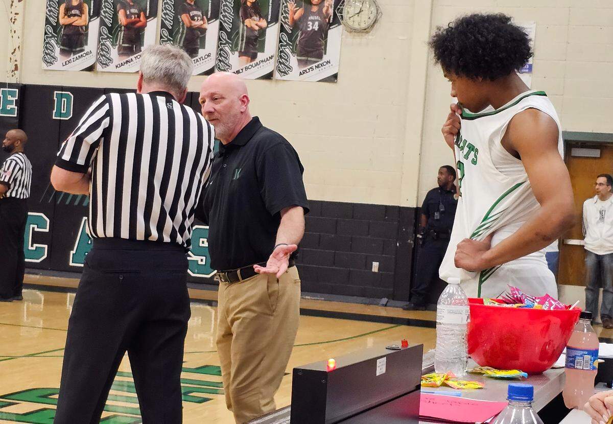 Kennedale boys basketball coach Doug Groff, center, confers with an official as Jayden Miller, right, looks on in a game against Venus on Friday, February 7, 2025 at Kennedale High School in Kennedale, Texas