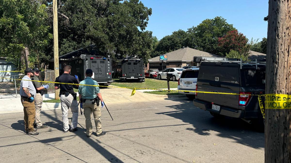 Law enforcement investigate in the 2900 block of Elinor Street near the home where a man barricaded himself after shooting a Tarrant County sheriff’s deputy three times on Aug. 7, 2024.