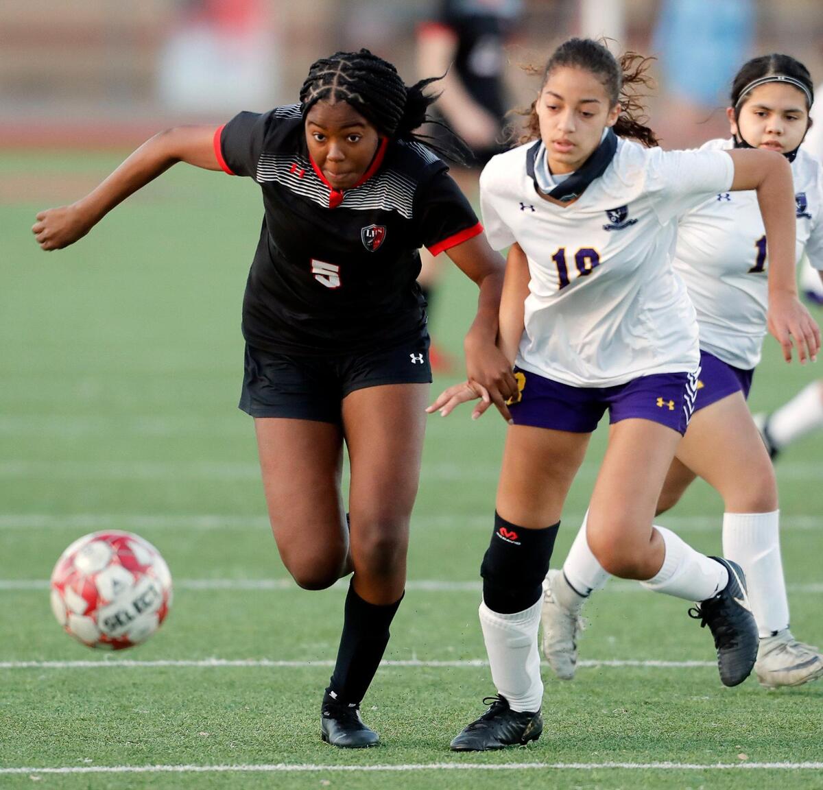 Legacy’s Jada Davis (5) and Everman’s Joycelyn King (18) chase a ball during a district 8-5A high school soccer game at Mansfield Legacy High School in Mansfield, Texas, Wednesday, March 03, 2021. Legacy defeated Everman 8-0. (Special to the Star-Telegram Bob Booth)