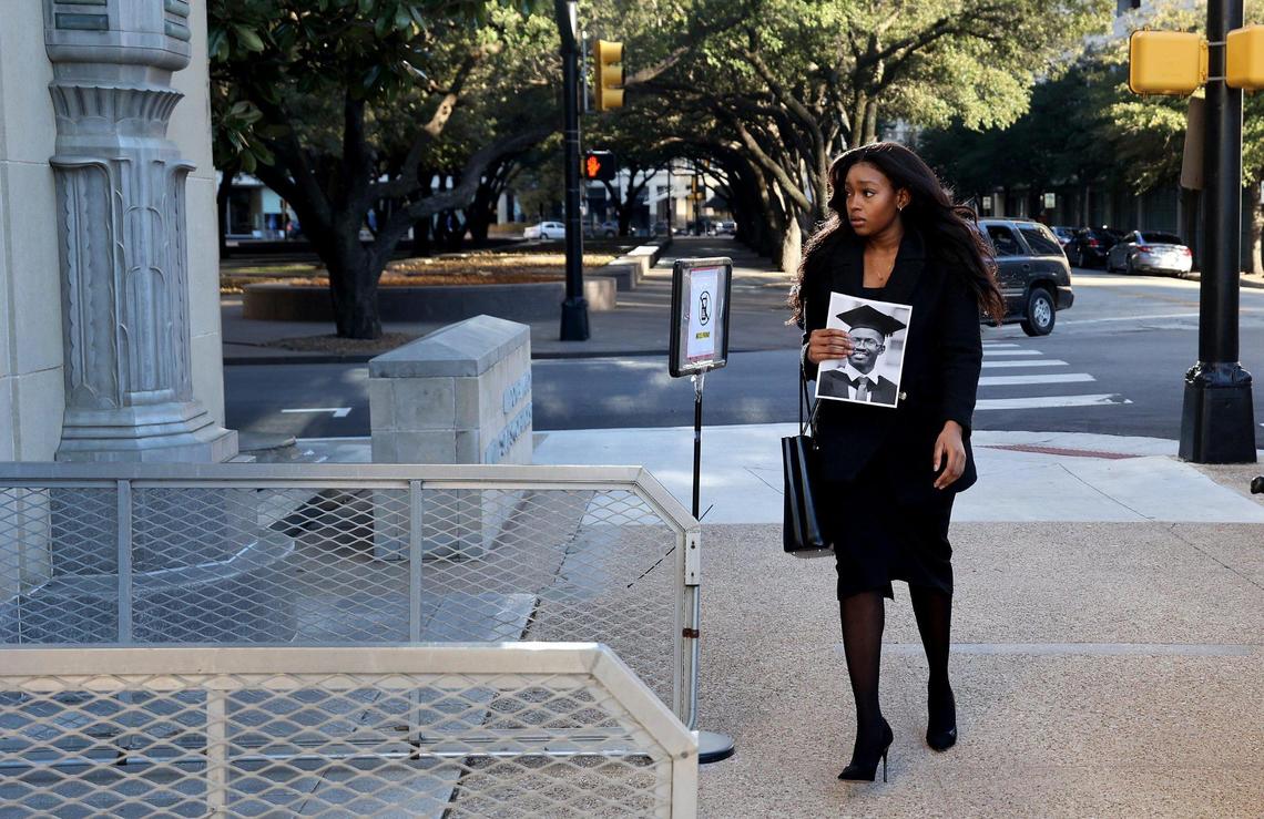 Zipporah Kuria walks into the Fort Worth federal courthouse while holding a photograph of her father, Joseph Kuria Waithaka, on Thursday, January 26, 2023. Kuria’s father was one of the 346 people killed in two plane crashes involving a Boeing 737 MAX. She and other family members attended an arraignment challenging the plea agreement Boeing made with the Justice Department that granted them immunity from criminal prosecution.