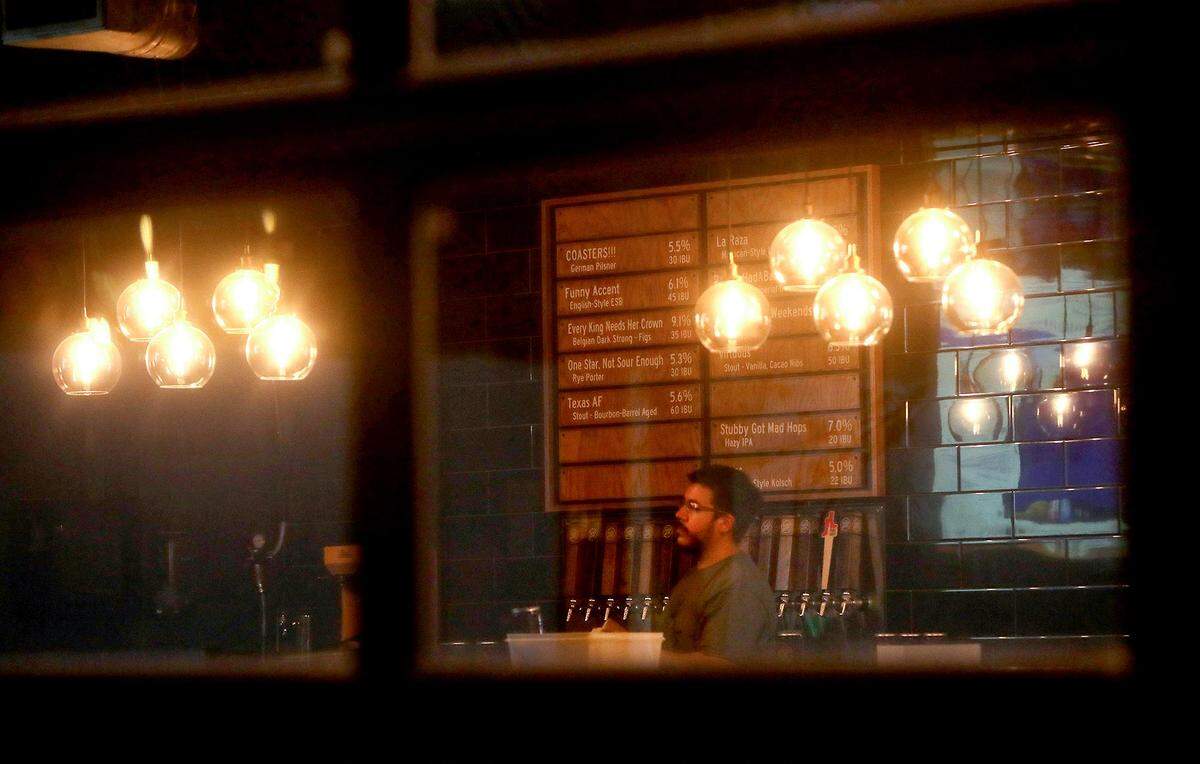The lone worker at Funky Picnic stands behind the bar in the empty dining room on Friday night, March 27, 2020. On most Friday nights the restaurant and bar is a popular spot, but with Fort Worth under a stay-at-home order restaurants can only offer take-out options.