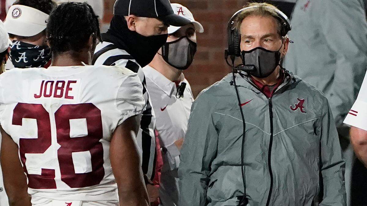 A masked Alabama coach Nick Saban speaks with defensive back Josh Jobe (28) during the second half of the team’s NCAA college football game against Mississippi in Oxford, Miss., Saturday, Oct. 10, 2020. Alabama won 63-48.