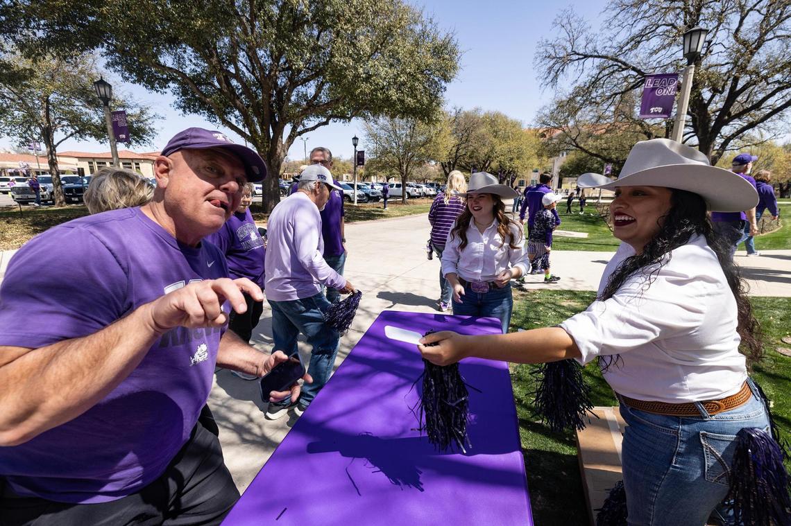 TCU fans receive pom-poms from TCU Rangers members Hollie Gomez, front, and Jen Willis, rear, prior to the first round game of the Women’s NCAA Championships Tournament game between TCU and Fairleigh Dickinson at Schollmaier Arena in Fort Worth on Friday, March 21, 2025.