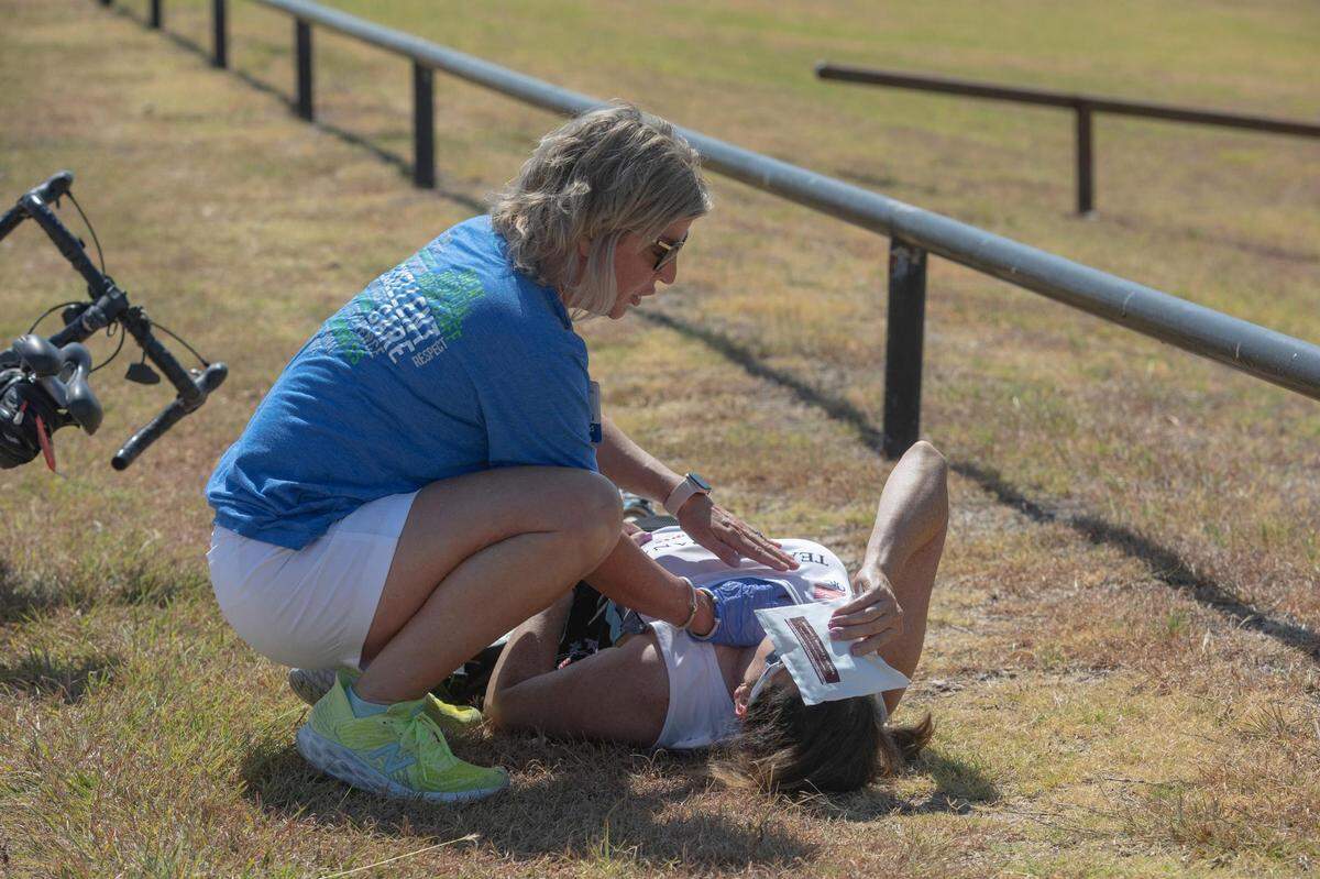 Registered nurse Anita Rigues helps bike rider Evonne Luddeka cool off after getting overheated during the Peach Pedal Bike Ride in Weatherford, Texas, on Saturday, July 9, 2022.