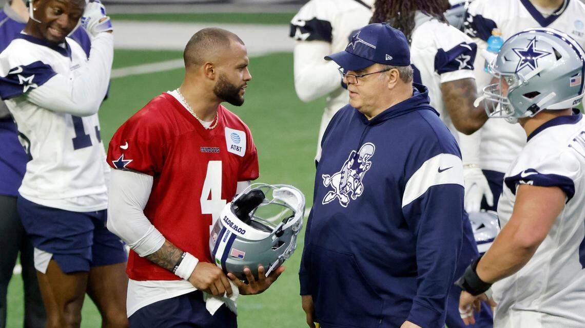 Dallas Cowboys quarterback Dak Prescott (4) talks to head coach Mike McCarthy, right, during NFL football practice at the team’s training facility in Frisco on Thursday.