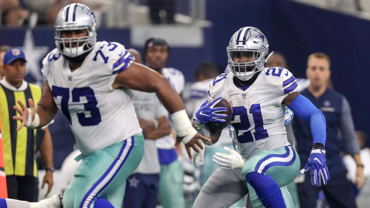 Cowboys running back Ezekiel Elliott, right, follows the block of center Joe Looney for a 38-yard touchdown reception against the Detroit Lions during the first half on Sunday at AT&T Stadium in Arlington.