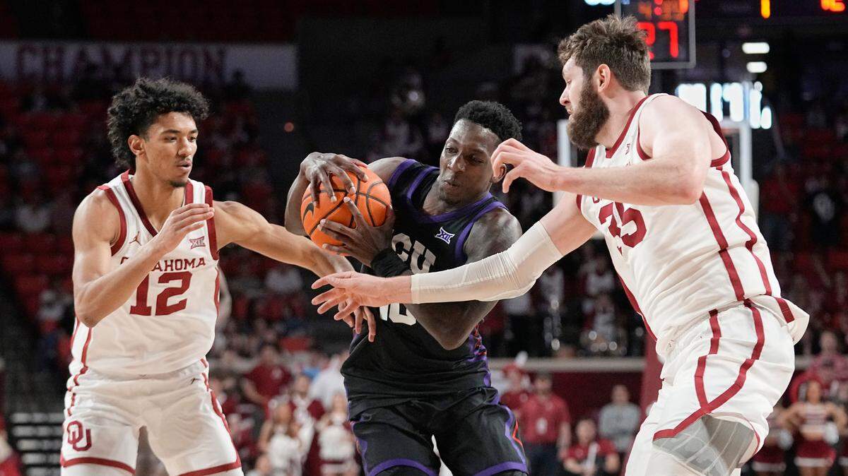 TCU guard Damion Baugh, center, drives between Oklahoma guard Milos Uzan (12) and forward Tanner Groves (35) during their game on Saturday in Norman, Okla.