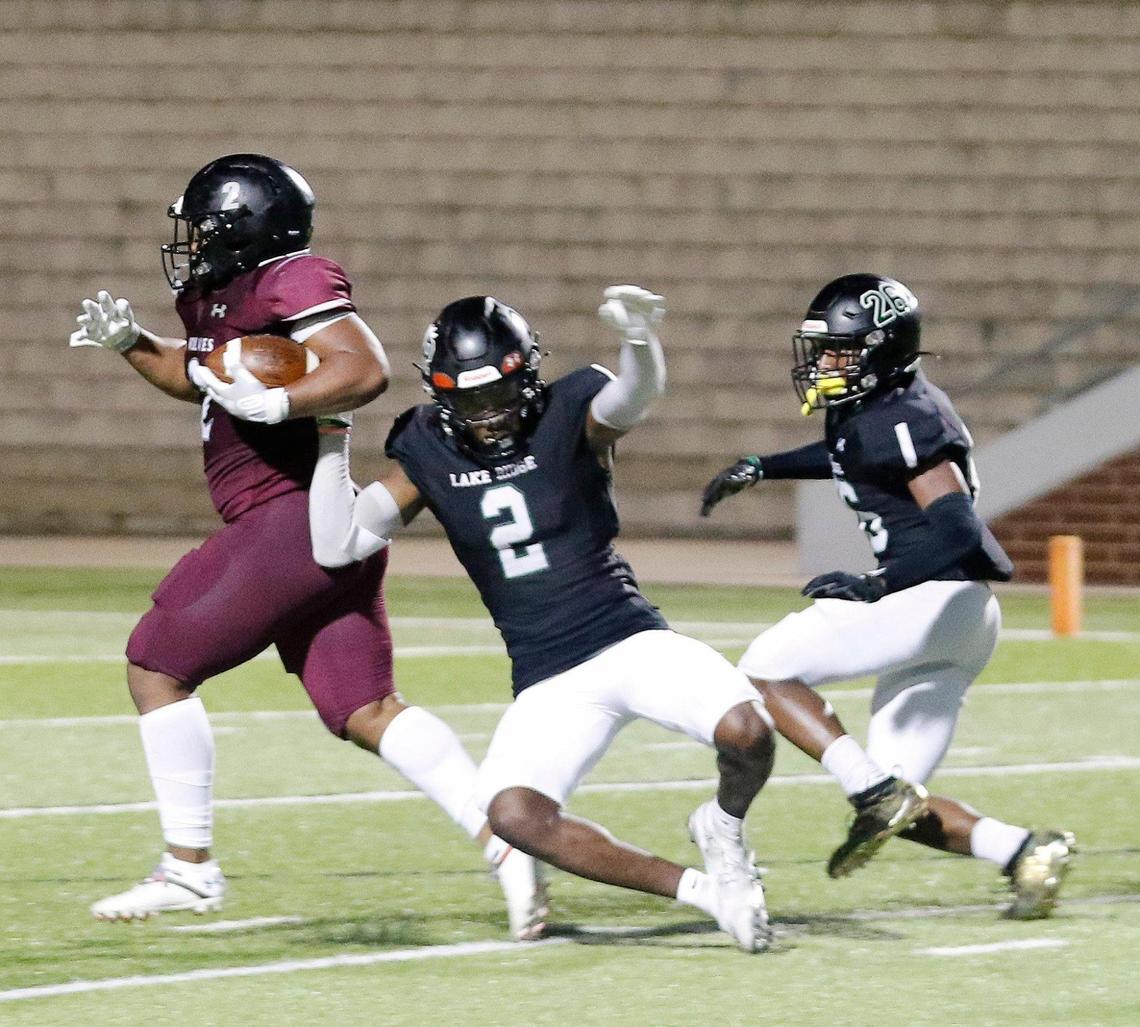 Timberview running back Deuce Jones (2) rumbles to the end zone for the winning score defended by Lake Ridge cornerbacks Marvin Covington (2) and Darrell James (26) during Thursday’s game at Vernon Newsom Stadium in Mansfield. Timberview defeated Lake Ridge 28-14.
