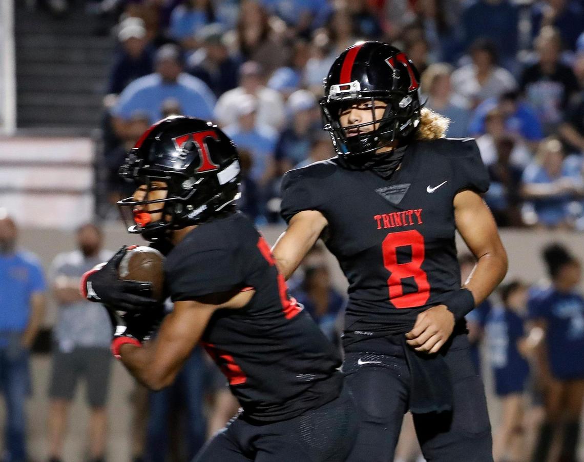 Trinity quarterback TJ Tupou (8) hands the ball to running back Josh Bell (20) in the first half of a District 3-6A high school football game at Pennington Field in Bedford, Texas, Thursday, Nov. 03, 2022. Trinity led L.D. Bell 14-7 at the half.(Special to the Star-Telegram Bob Booth)