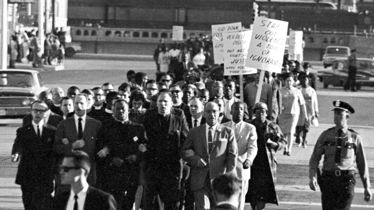 During Fort Worth’s first biracial civil rights demonstration on March 14, 1965, more than 600 demonstrators linked arms and silently walked five-abreast to City Hall. Leading the march was the Rev. Marshall Hodge, local president of the Southern Christian Leadership Conference, who wore clerical clothing and walked arm-in-arm with Rabbi Robert Schur, who wore a suit and dark tie. The rabbi’s involvement mobilized white clergy to participate.