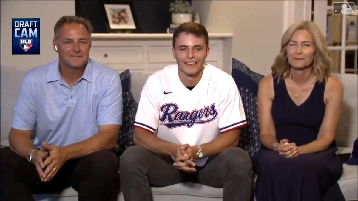 Jack Leiter, wearing a Texas Rangers jersey moments after being taken as the No. 2 overall pick in the MLB Draft by the club Sunday evening. He’s sitting between his parents, former MLB All-Star Al Leiter and mom Lori.