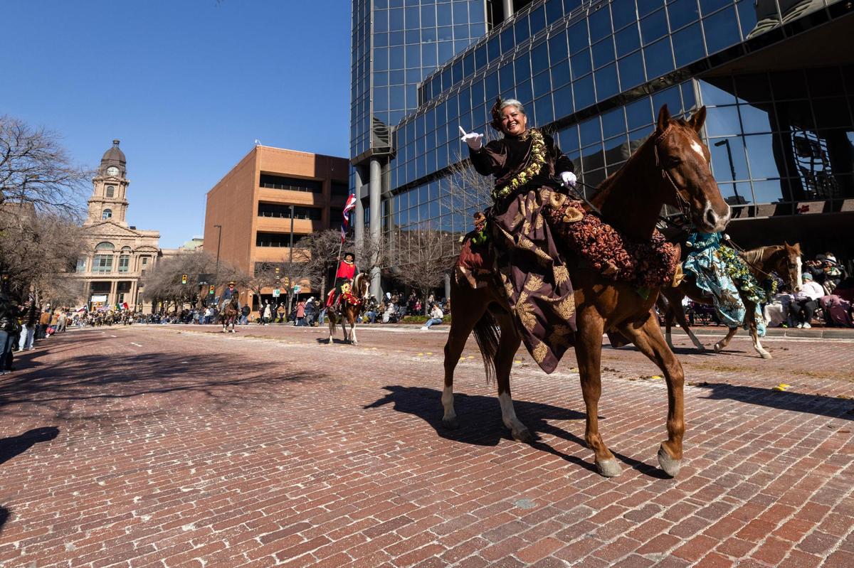 Members of the Hawaii Pa’u Riders cheers them on as they make their way down Main Street during the Fort Worth Stock Show All Western Parade in downtown Fort Worth on Saturday, Jan. 18, 2025.