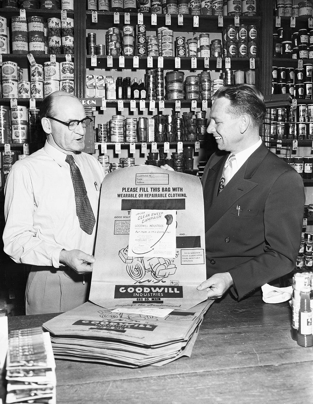 Feb. 23, 1954: Wayne Presley, right, member of the Junior Chamber of Commerce committee collecting clothes and footwear for Goodwill Industries, leaves a bundle of sacks with Lloyd F. Hallaran, manager of Turner & Dingee Quality Foods. (The store, at West Seventh and Macon streets, is today a parking lot by First United Methodist Church.)