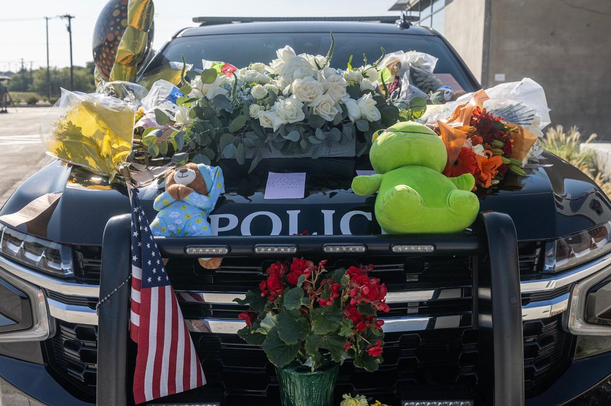 Flowers, handwritten notes and other items are placed on the patrol vehicle in memory of the late Fort Worth Police Department Sgt. Billy Randolph at Fort Worth PD South Division headquarters in Fort Worth on Tuesday. Sgt. Randolph was struck by a vehicle while working a crash scene on the exit ramp of I-35W near Sycamore School Road on Monday morning.