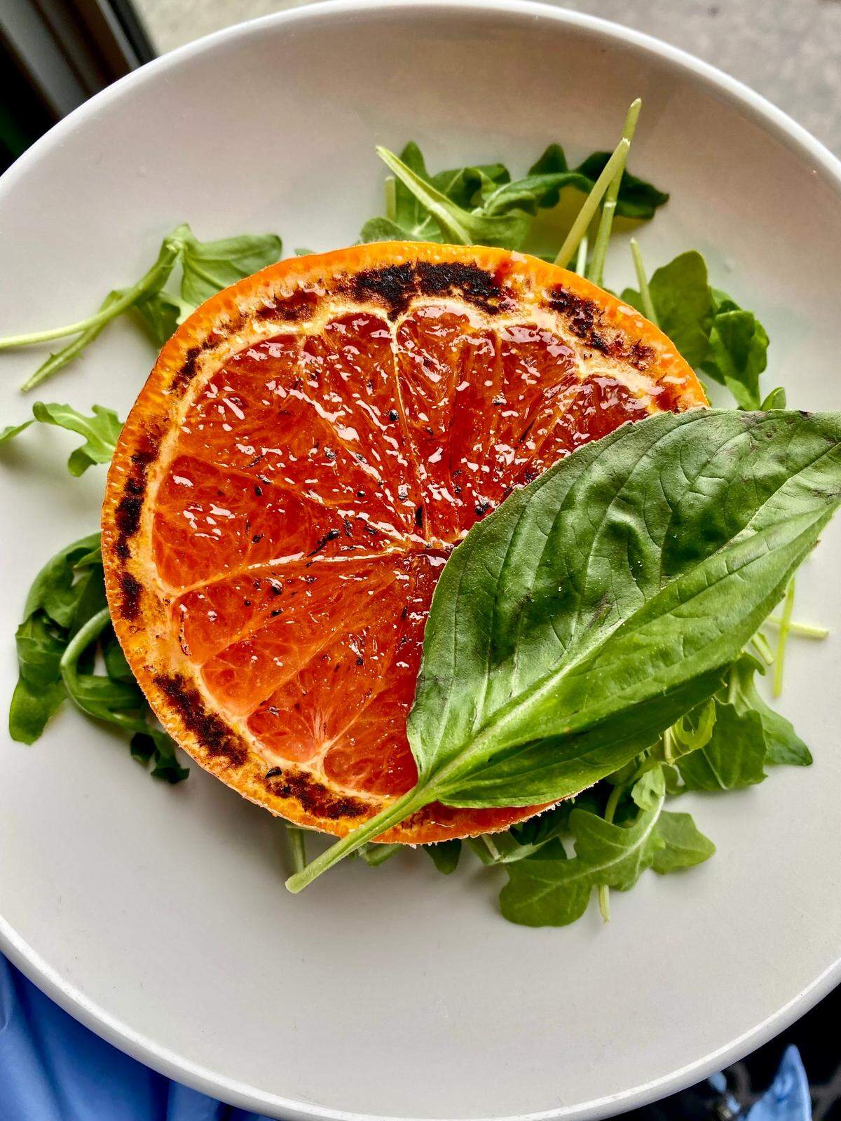 A bruleed grapefruit half with arugula at Gemelle and the new Hotel Otto.